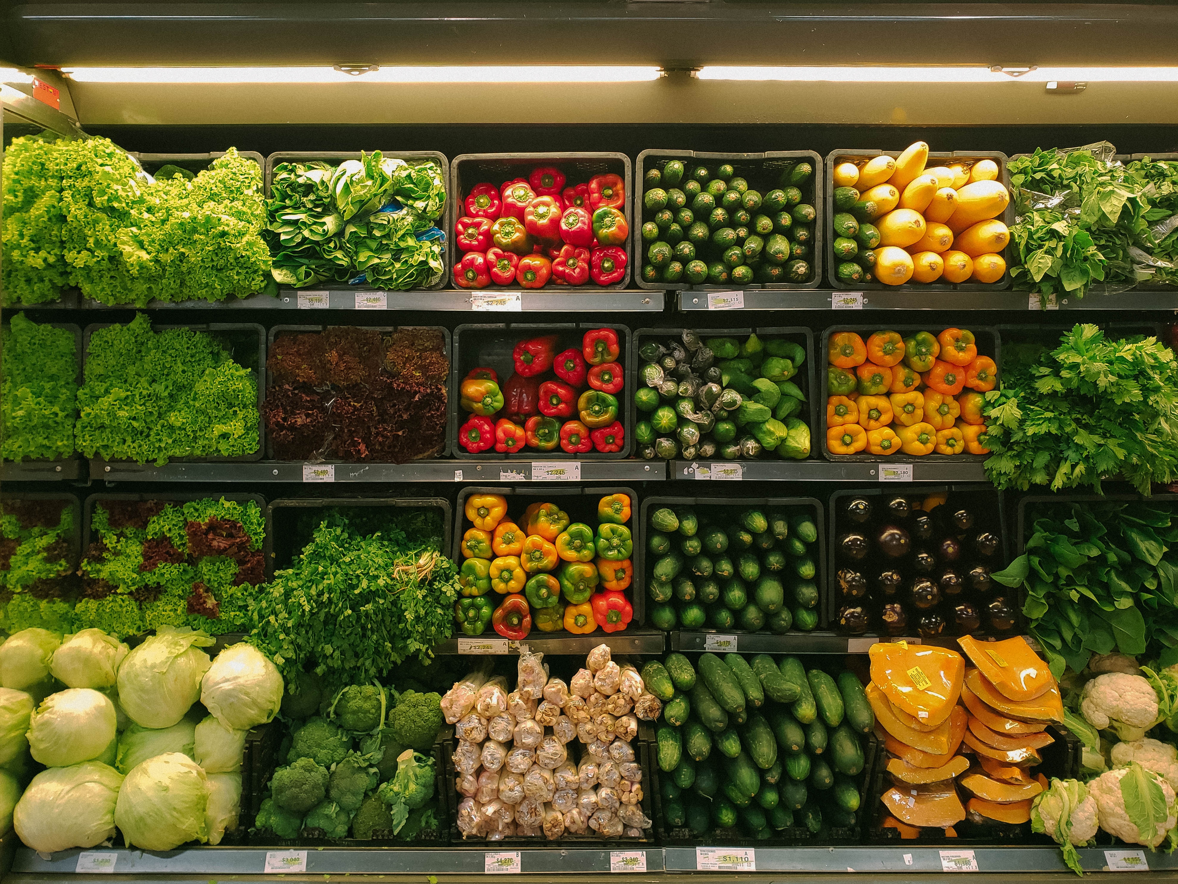 На прилавках магазинов лежат отборные овощи. Овощи и фрукты. Овощи на прилавке. Выкладка овощей и фруктов в магазине. Прилавок с фруктами.
